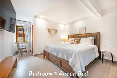 a bedroom with a bed and a dining room at Main Villa plus 2 casitas, 5 BR, POOL, canaba w grill in Tamarindo