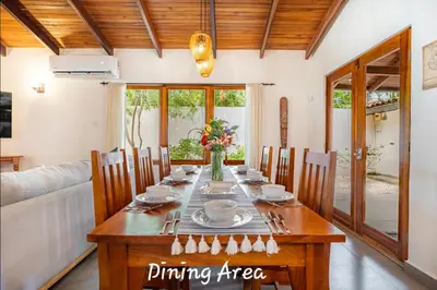 a dining room with a wooden table and chairs at Main Villa plus 2 casitas, 5 BR, POOL, canaba w grill in Tamarindo