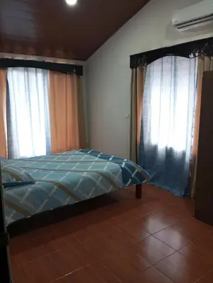 a bedroom with a bed and two windows at Linda vista in Bijagua