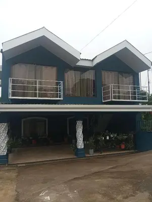 a blue house with a balcony on top of it at Linda vista in Bijagua