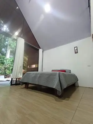 a bedroom with a bed and a large window at Kono Rainbow Finca paraíso in Jiménez