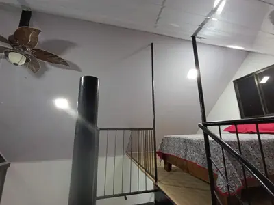 a bedroom with a ceiling fan and a bed at Kono Rainbow Finca paraíso in Jiménez
