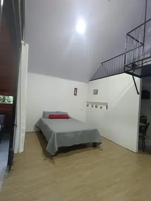 a white room with a bed and a staircase at Kono Rainbow Finca paraíso in Jiménez