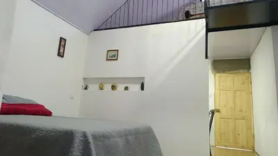 a bedroom with a bed and a wooden door at Kono Rainbow Finca paraíso in Jiménez