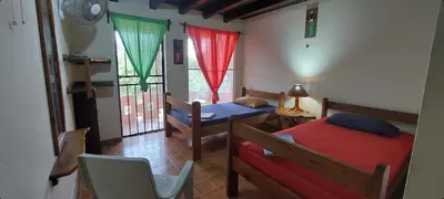 a bedroom with two beds and a table and a chair at El Castillo Divertido in Paraíso