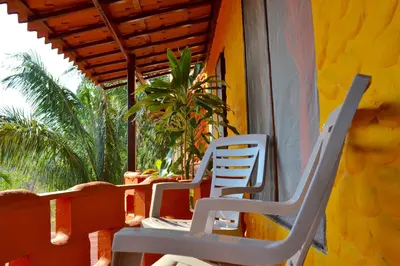 two chairs sitting on the porch of a house at El Castillo Divertido in Paraíso