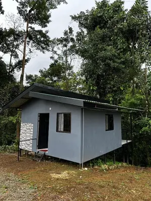 a small grey house with a black roof at Chava Lodge On Tenorio Rio Celeste in Rio Celeste