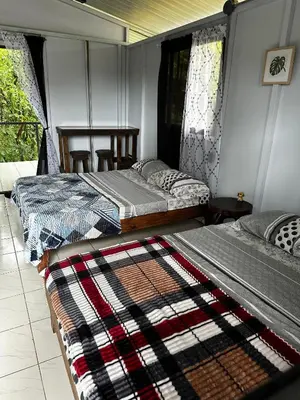 two beds sitting in a room with at Chava Lodge On Tenorio Rio Celeste in Rio Celeste