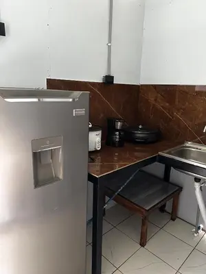 a small kitchen with a table and a refrigerator at Chava Lodge On Tenorio Rio Celeste in Rio Celeste