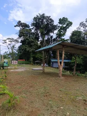 a pavilion with a blue roof in a field at Chava Lodge On Tenorio Rio Celeste in Rio Celeste