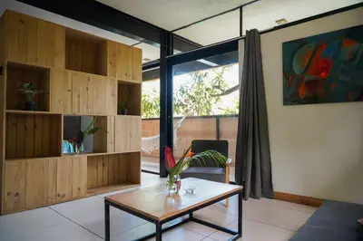 a living room with a coffee table and a large window at VED Beach Apt 5 - Steps to the Beach in Santa Teresa Beach