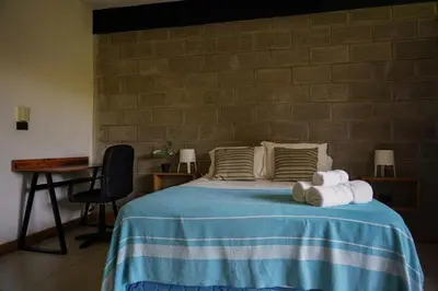 a bedroom with a bed with towels on it at VED Beach Apt 5 - Steps to the Beach in Santa Teresa Beach