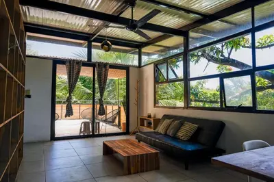 a living room with a couch and a table at VED Beach Terrace Apt 6 - Steps to the Beach in Santa Teresa Beach