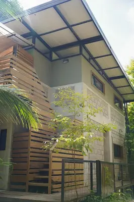a house with a wooden staircase in front of it at VED Beach Terrace Apt 6 - Steps to the Beach in Santa Teresa Beach