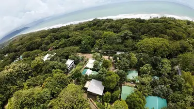 an aerial view of an island with trees and blue water at VED Beach Terrace Apt 6 - Steps to the Beach in Santa Teresa Beach
