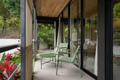 a patio with chairs and a table and some plants at VED Beach Apt 1 - 1BDR, Pool, Steps to the Beach in Santa Teresa Beach