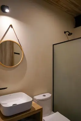 a bathroom with a white toilet and a mirror at VED Beach Apt 1 - 1BDR, Pool, Steps to the Beach in Santa Teresa Beach