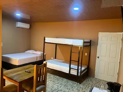 a room with two bunk beds and a table at Luisito steak House & Hotel in Fortuna
