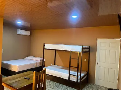 a room with two bunk beds and a table at Luisito steak House & Hotel in Fortuna