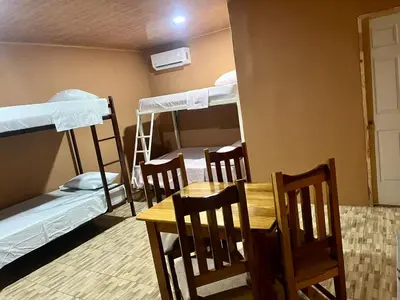 a room with a table and chairs and bunk beds at Luisito steak House & Hotel in Fortuna