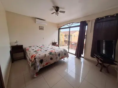 a bedroom with a bed and a flat screen tv at Villa Prados del Rio 47 in Comunidad