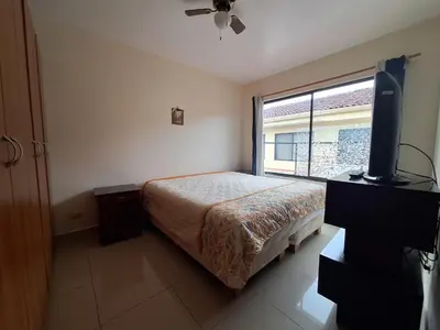a bedroom with a bed and a flat screen tv at Villa Prados del Rio 47 in Comunidad