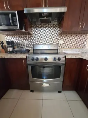 a kitchen with a stove and a microwave at Villa Prados del Rio 47 in Comunidad
