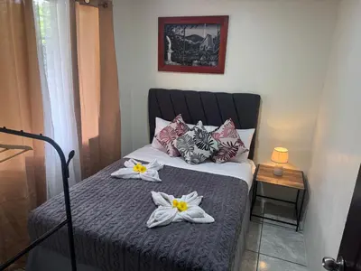 a bedroom with a bed with flowers on it at Casa Colibrí Encanto Rústico y Comodidad Moderna -La Fortuna in Fortuna