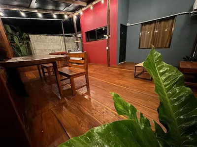 a room with a table and chairs and a red door at Casa Colibrí Encanto Rústico y Comodidad Moderna -La Fortuna in Fortuna