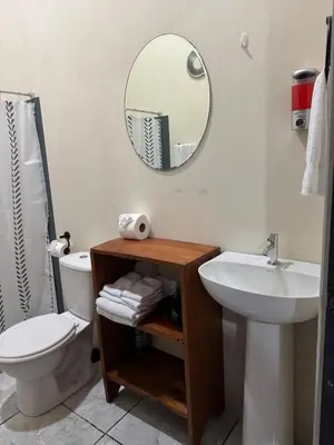 a bathroom with a sink and a toilet and a mirror at Casa Colibrí Encanto Rústico y Comodidad Moderna -La Fortuna in Fortuna