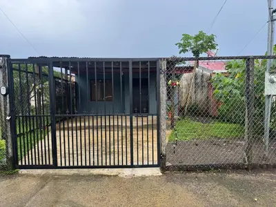 a gate to a yard with a house at Casa Colibrí Encanto Rústico y Comodidad Moderna -La Fortuna in Fortuna