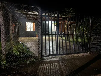 an entrance to a house with a gate at night at Casa Colibrí Encanto Rústico y Comodidad Moderna -La Fortuna in Fortuna