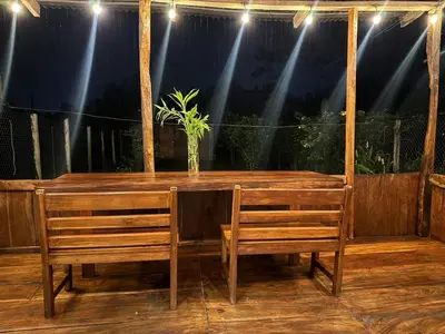 a wooden table with two chairs and a plant on it at Casa Colibrí Encanto Rústico y Comodidad Moderna -La Fortuna in Fortuna