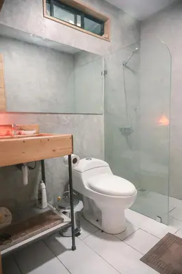 a bathroom with a toilet and a glass shower at Jungle house in Santa Teresa in Santa Teresa Beach