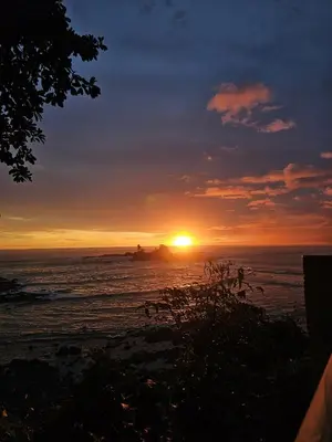 a sunset over the ocean with the sun setting at Cabinas La Parcela in Dominicalito