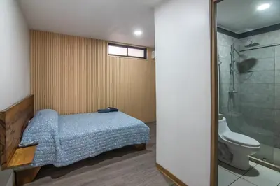 a bedroom with a bed and a shower and a toilet at Japandi Tropical Stay in Puntarenas