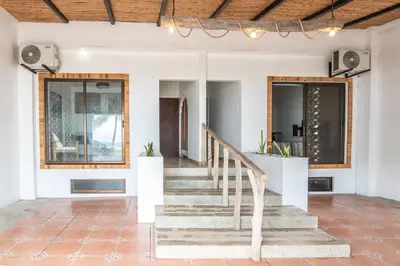 a staircase in a home with white walls and wooden ceilings at Japandi Tropical Stay in Puntarenas