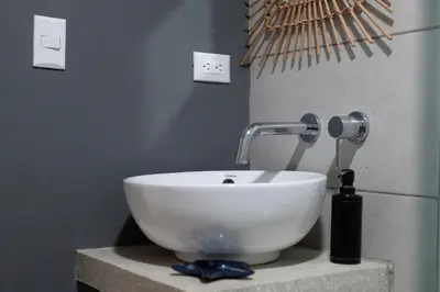 a white bowl sink sitting on a counter in a bathroom at Japandi Tropical Stay in Puntarenas