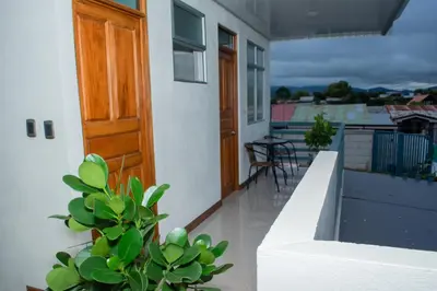 a balcony with a wooden door and a table and chairs at Mi Barrio in Cartago