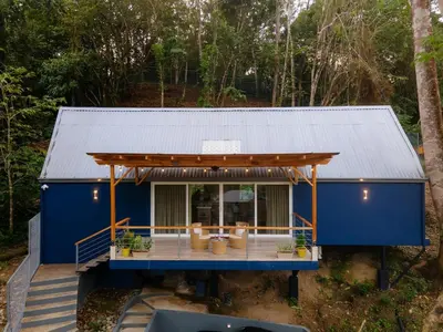 a blue house with a metal roof at Modern 2BR Home in Central Manuel Antonio! in Quepos