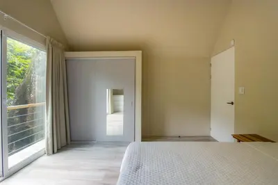 a bedroom with a bed and a large window at Modern 2BR Home in Central Manuel Antonio! in Quepos