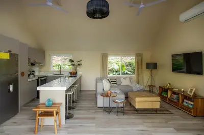 a kitchen and living room with a couch and a table at Modern 2BR Home in Central Manuel Antonio! in Quepos