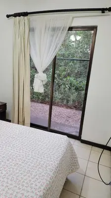 a bedroom with a bed and a large window at Playas del Coco Cocomarindo 23 in Coco