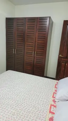 a bedroom with a bed and some wooden cabinets at Playas del Coco Cocomarindo 23 in Coco