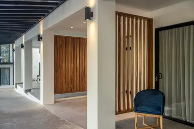 a hallway with sliding glass doors and a blue chair at Ocotea Boutique Hotel in Monteverde Costa Rica