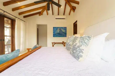 a bedroom with a large white bed with pillows at Casa Brisa At Las Catalinas in Playa Danta