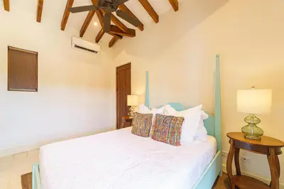 a bedroom with a white bed with a ceiling at Casa Brisa At Las Catalinas in Playa Danta