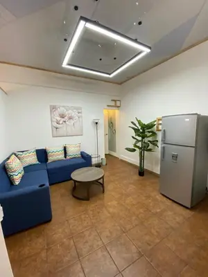 a living room with a blue couch and a refrigerator at Apt Barrio Mexico in San José