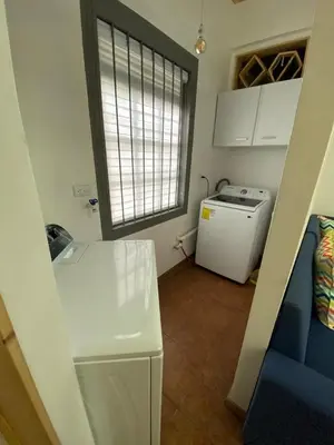 a small kitchen with a refrigerator and a window at Apt Barrio Mexico in San José