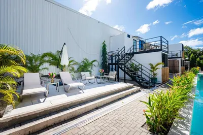 a patio with chairs and a swimming pool at Nomad Containers - Adults only in Tamarindo